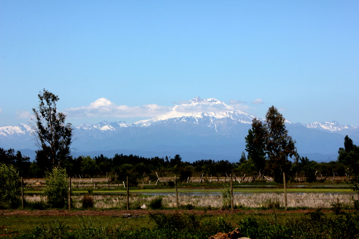 Paisaje panorámico de la Región del Maule, Chile, con la Cordillera de los Andes y valles verdes al atardecer